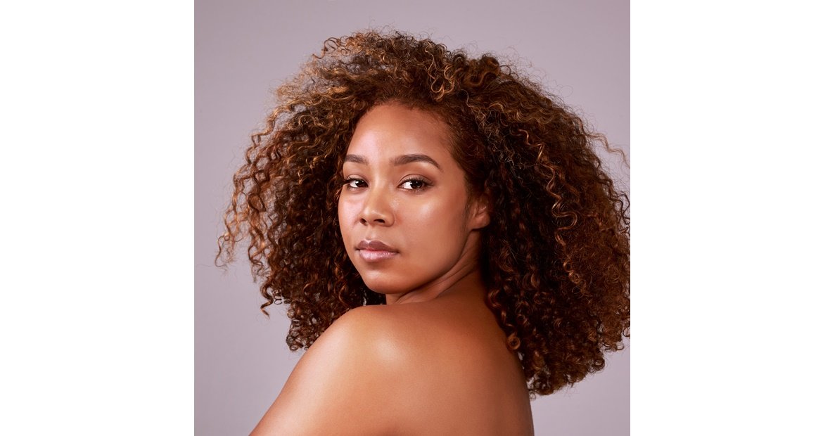 mulher negra com cabelo cacheado com corte de cabelo em coração